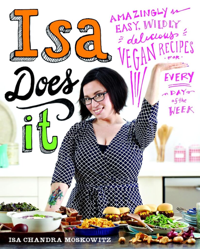 Isa Does It vegan cookbook on a kitchen counter with prepared dishes